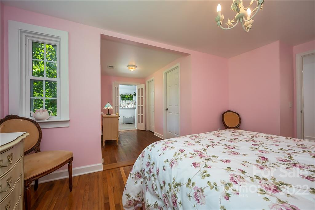146 Hidden Hill Road Tryon, NC 28782 - Photo 19 of 43 a bedroom with a bed and a chandelier