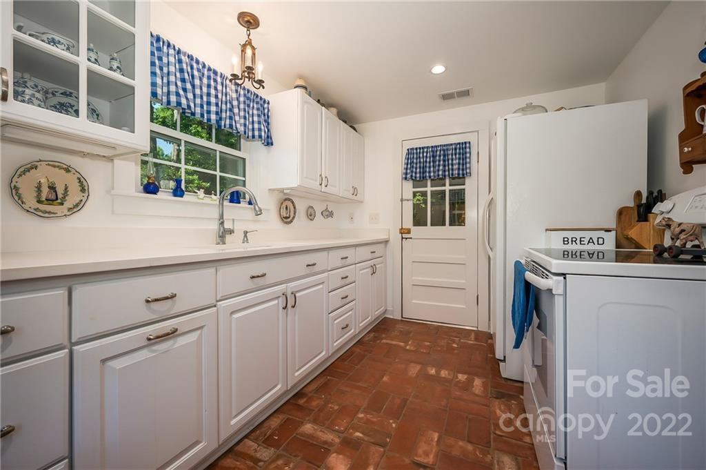 146 Hidden Hill Road Tryon, NC 28782 - Photo 7 of 43 a kitchen with a sink a stove cabinets and a window