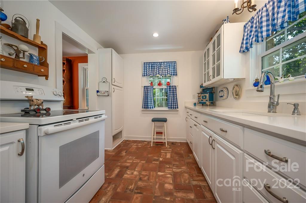 146 Hidden Hill Road Tryon, NC 28782 - Photo 8 of 43 a kitchen with white cabinets and sink