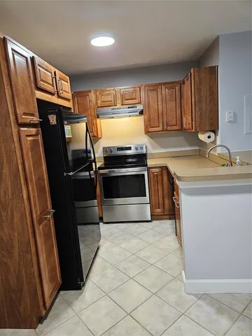 a kitchen with stainless steel appliances a stove a refrigerator and a sink