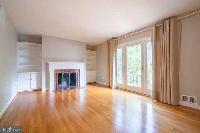 wooden floor fireplace and windows in an empty room
