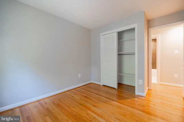 a view of empty room with wooden floor