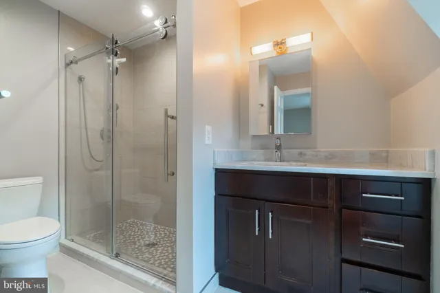 a bathroom with a shower sink vanity and mirror
