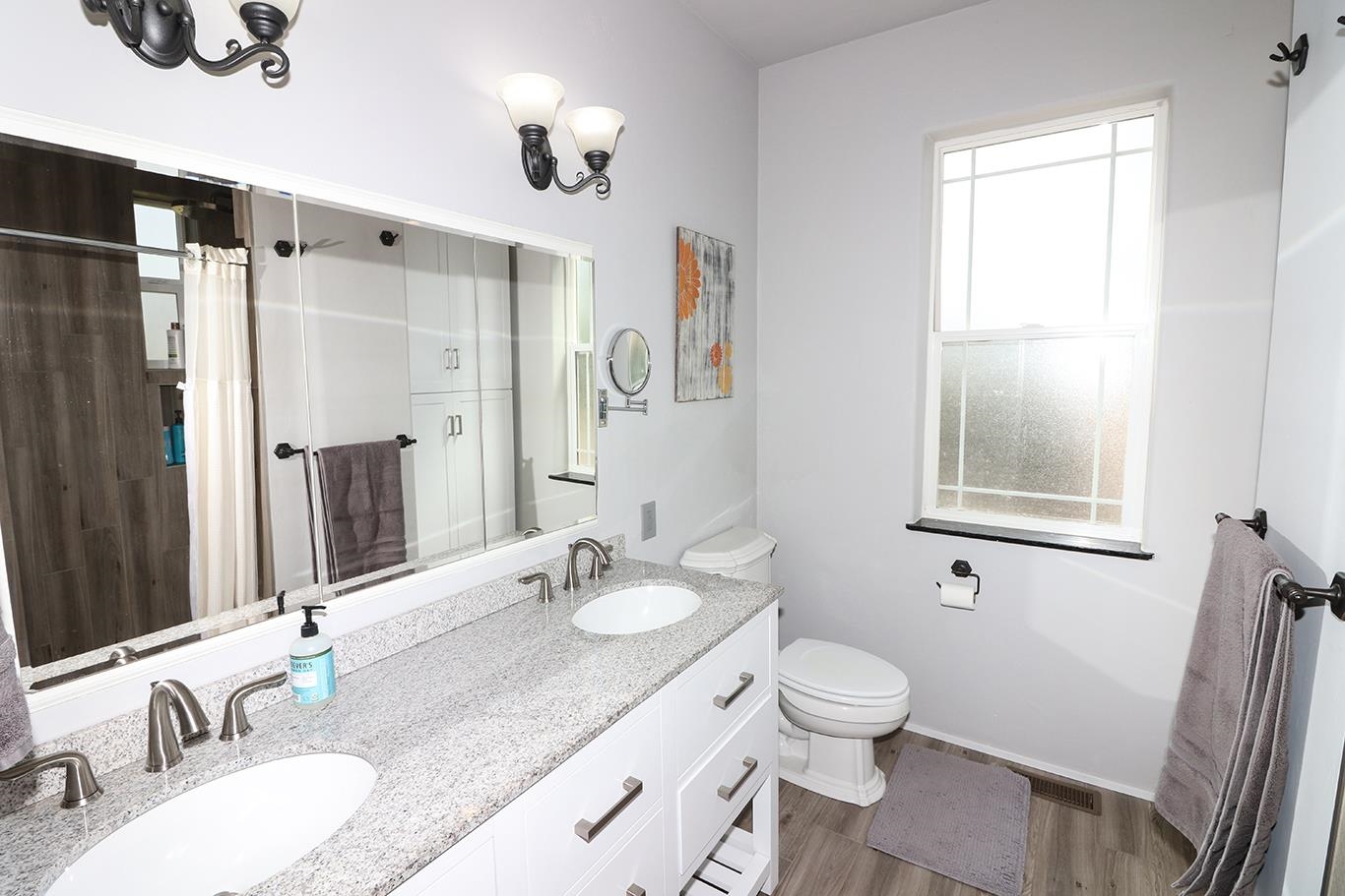 1198 23 Road Grand Junction, CO 81505 - Photo 14 of 32 a bathroom with a granite countertop sink toilet a large mirror and shower