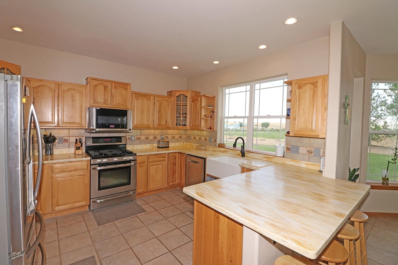 1198 23 Road Grand Junction, CO 81505 - Photo 9 of 32 a kitchen with stainless steel appliances granite countertop a sink stove microwave and refrigerator