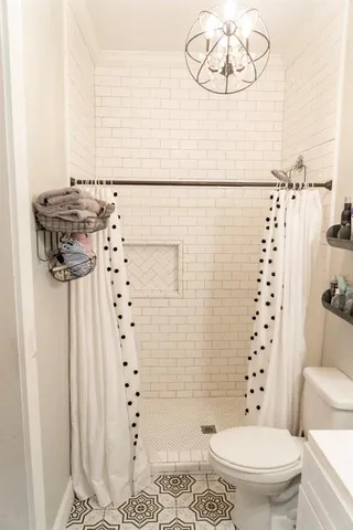 a bathroom with a toilet and a shower