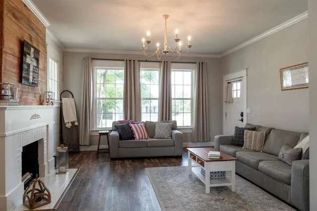 a living room with furniture a chandelier and a fireplace