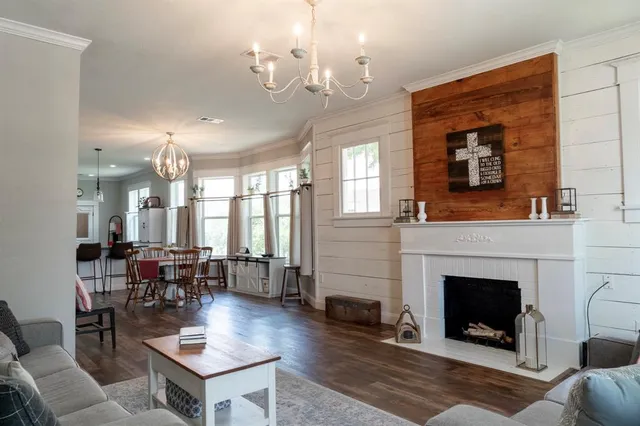a living room with furniture a fireplace and a chandelier
