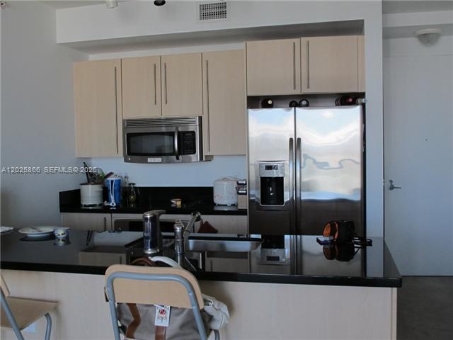 79 Southwest 12th Street, Unit 2911S Miami, FL 33130 - Photo 2 of 9 a living room with furniture a flat screen tv and a fireplace