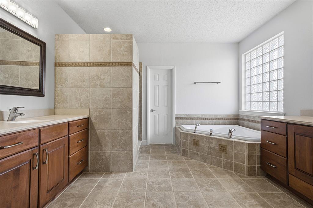 4425 Foxtail Lane Plano, TX 75024 - Photo 20 of 33 a spacious bathroom with a double vanity sink large mirror and a bathtub