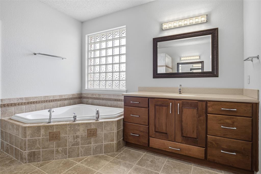 4425 Foxtail Lane Plano, TX 75024 - Photo 21 of 33 a bathroom with a tub a sink and mirror