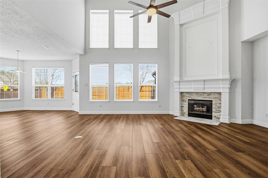 4425 Foxtail Lane Plano, TX 75024 - Photo 4 of 33 an empty room with windows fireplace and wooden floor