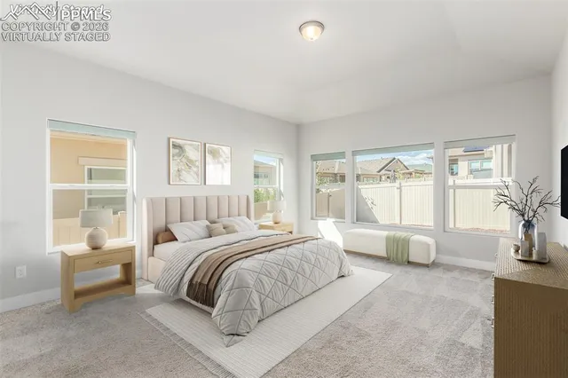 a bedroom with a bed and large windows