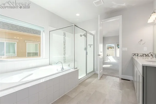 a spacious bathroom with a tub sink shower and mirror