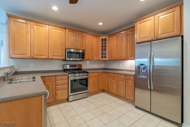 a kitchen with stainless steel appliances granite countertop a refrigerator stove top oven a sink and dishwasher
