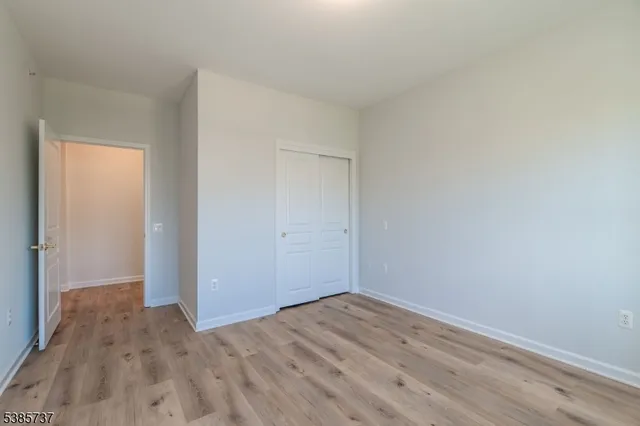 a view of a room with wooden floor and white walls
