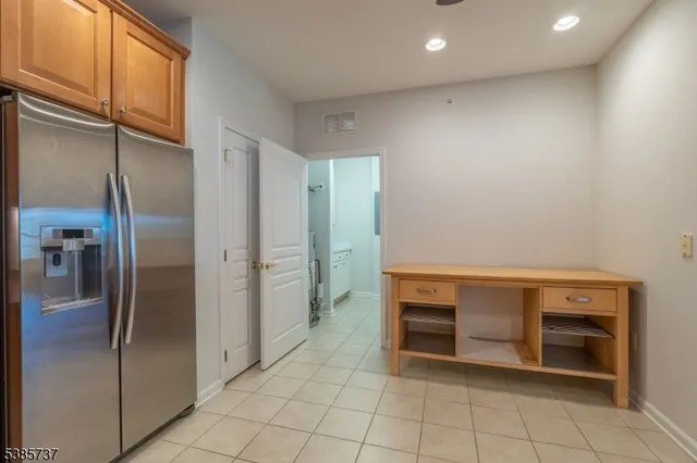 a view of a kitchen with refrigerator and more cabinets