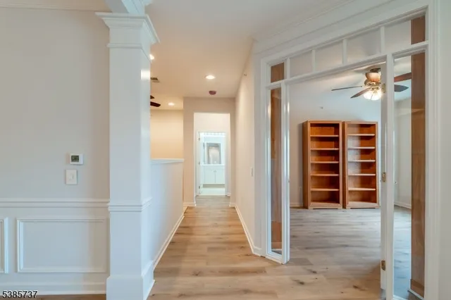 a view of a hallway with wooden floor and closet