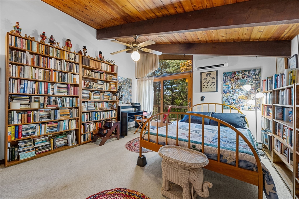 25 Resolution Road Truro, MA 02666 - Photo 25 of 42 a living room with lots of furniture and a book shelf
