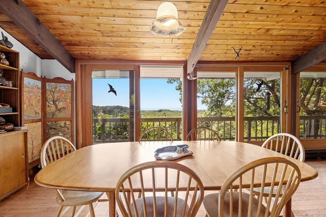 a dining room with furniture a chandelier and wooden floor