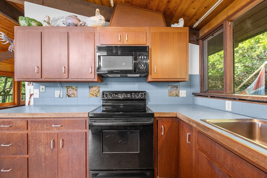 25 Resolution Road Truro, MA 02666 - Photo 10 of 42 a kitchen with stainless steel appliances granite countertop a stove a sink and a microwave