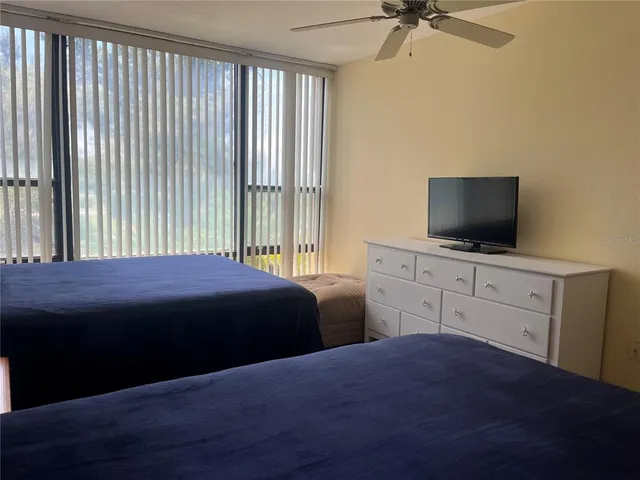 a bedroom with a bed and a flat tv screen on dresser