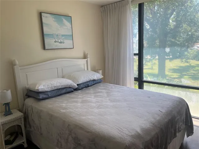 a bedroom with a bed and a large window