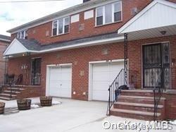 View of front of house with a garage, brick siding, and concrete driveway