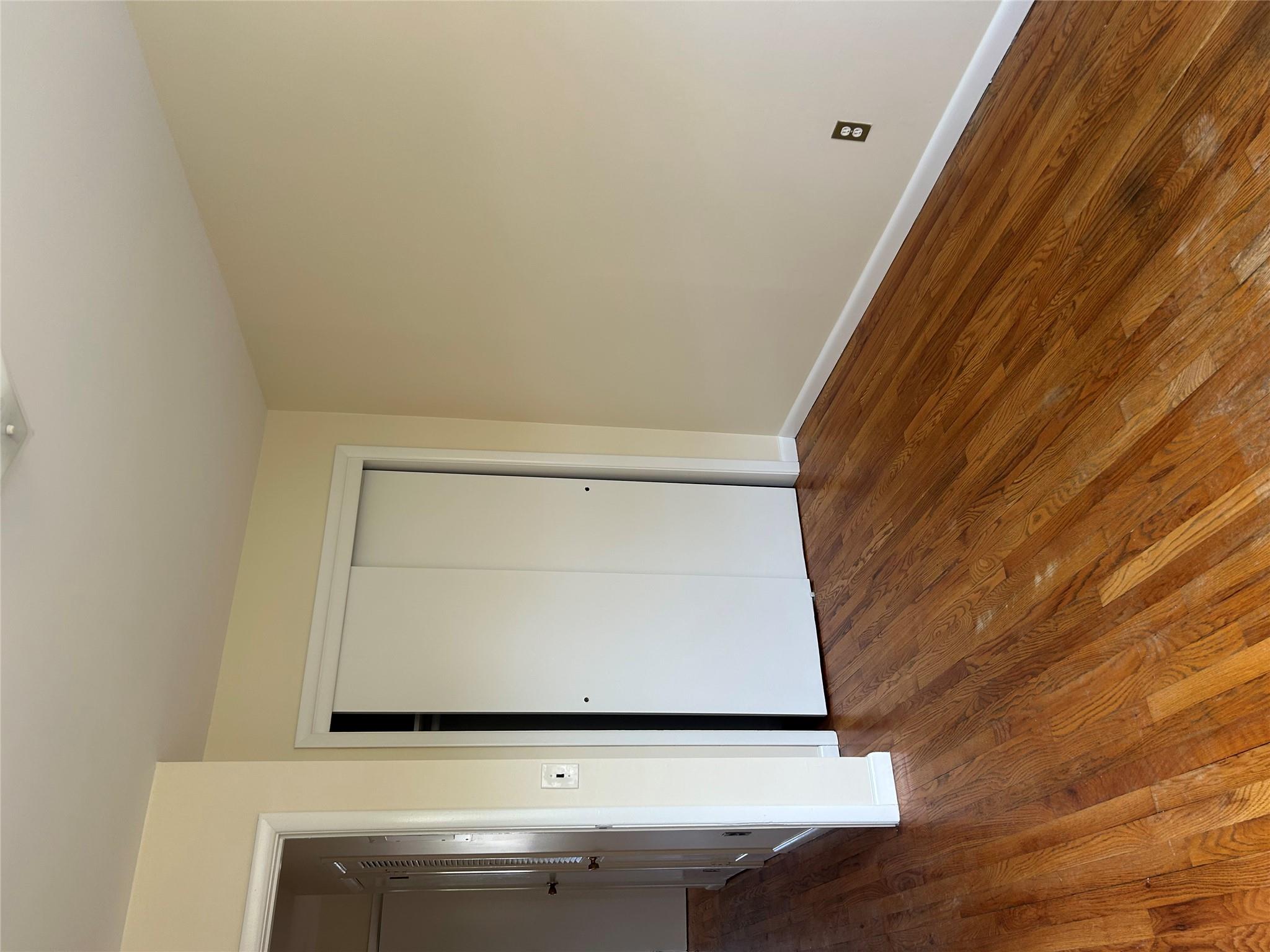 206-18 45th Road, Unit SECOND Queens, NY 11361 - Photo 12 of 14 Unfurnished bedroom featuring baseboards, a closet, and wood finished floors