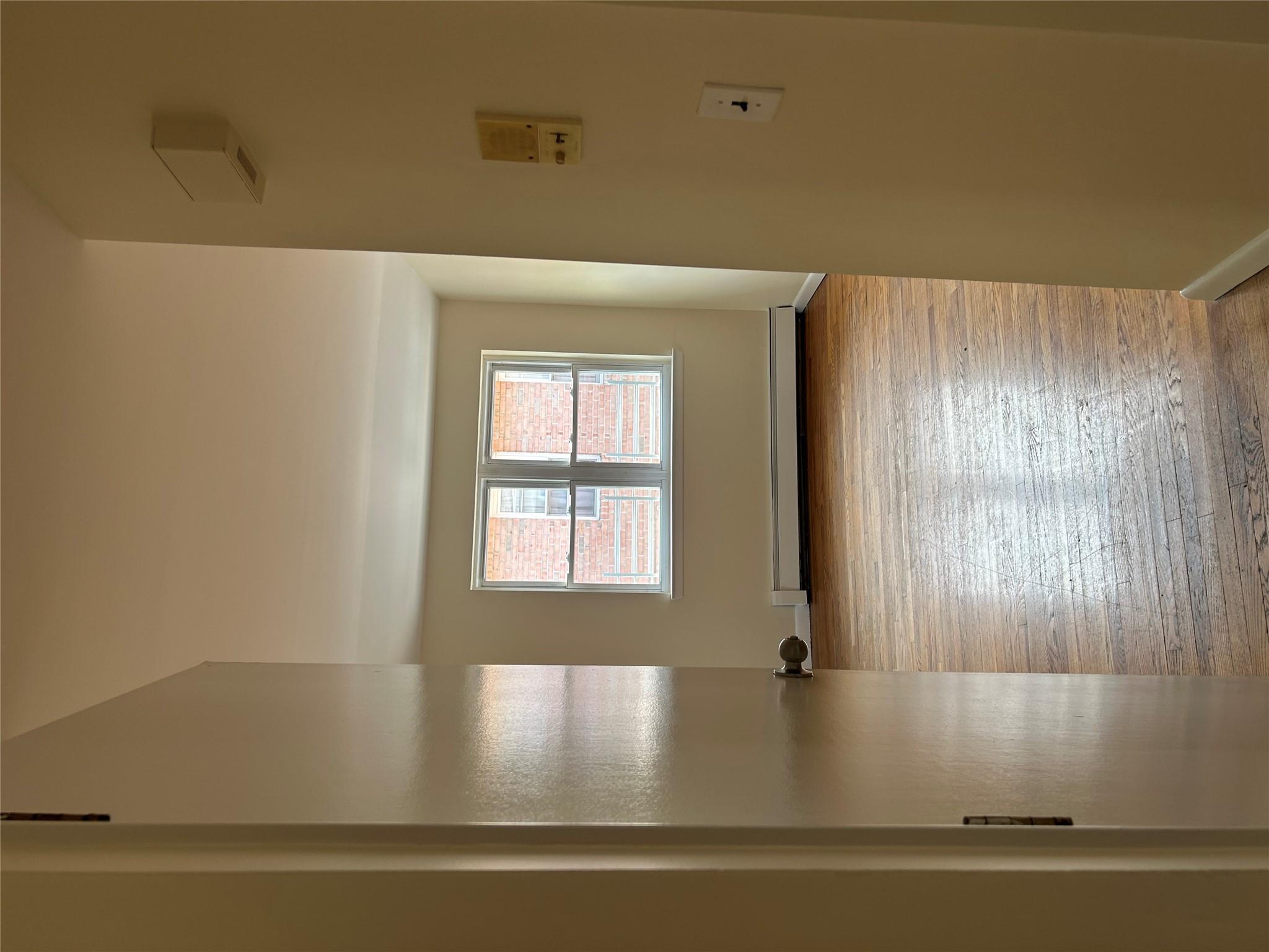 206-18 45th Road, Unit SECOND Queens, NY 11361 - Photo 14 of 14 Empty room featuring a baseboard heating unit, hardwood / wood-style flooring, and baseboards