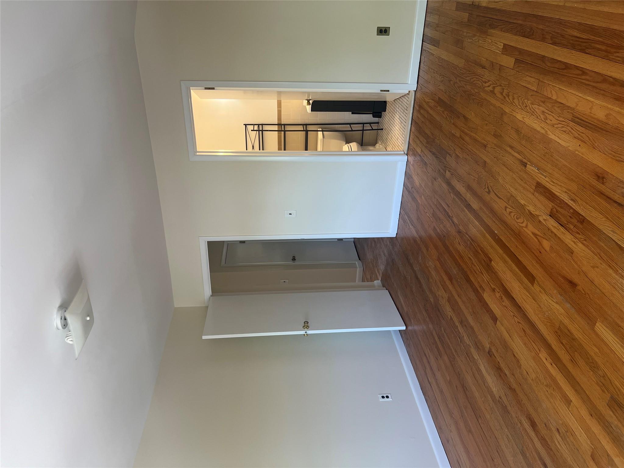 206-18 45th Road, Unit SECOND Queens, NY 11361 - Photo 2 of 14 Unfurnished bedroom with wood finished floors, baseboards, vaulted ceiling, and ensuite bathroom