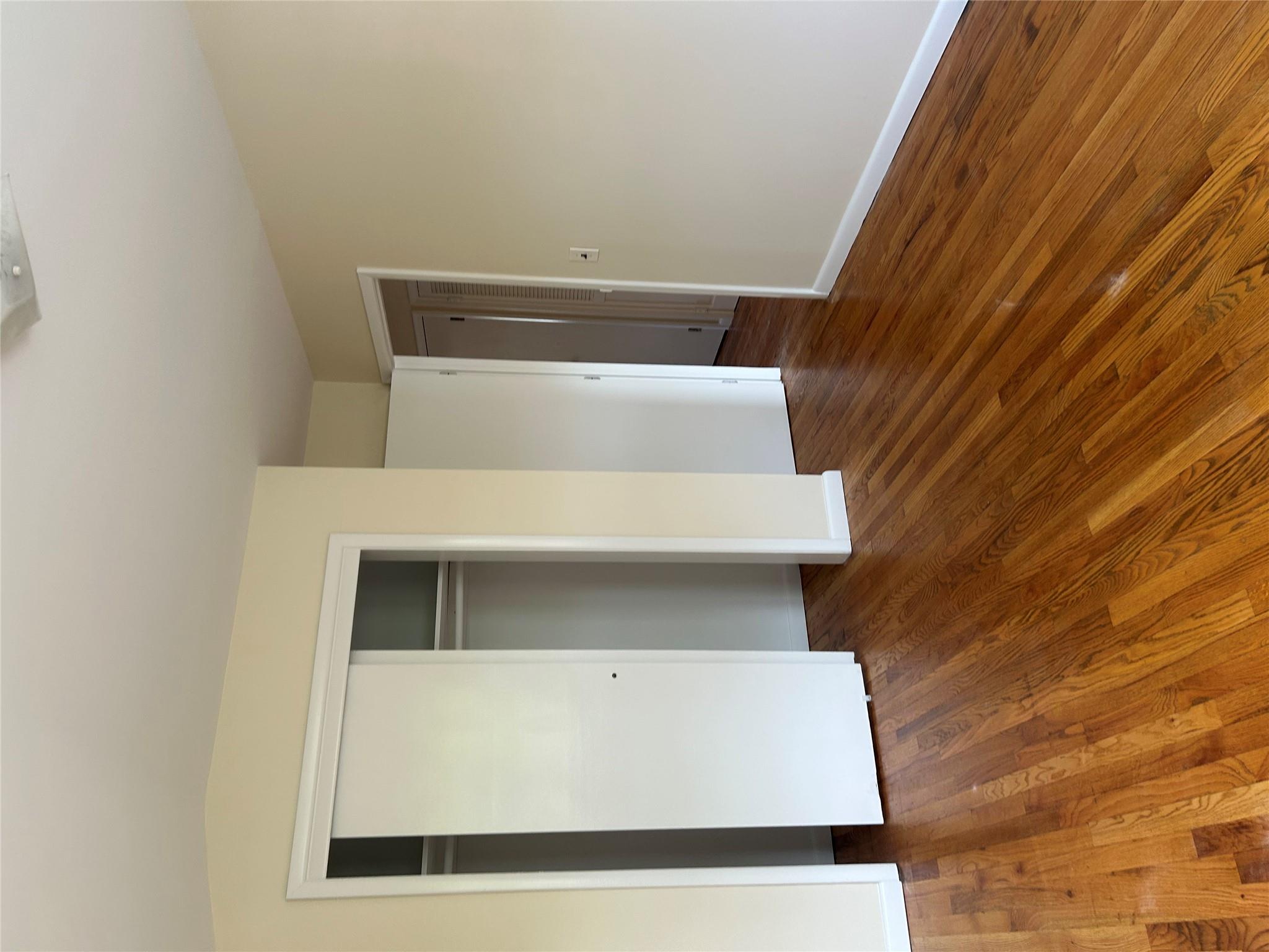 206-18 45th Road, Unit SECOND Queens, NY 11361 - Photo 10 of 14 Unfurnished bedroom with a closet, wood finished floors, and baseboards