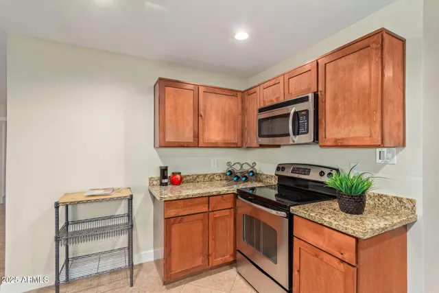 a kitchen with stainless steel appliances granite countertop a sink stove and microwave
