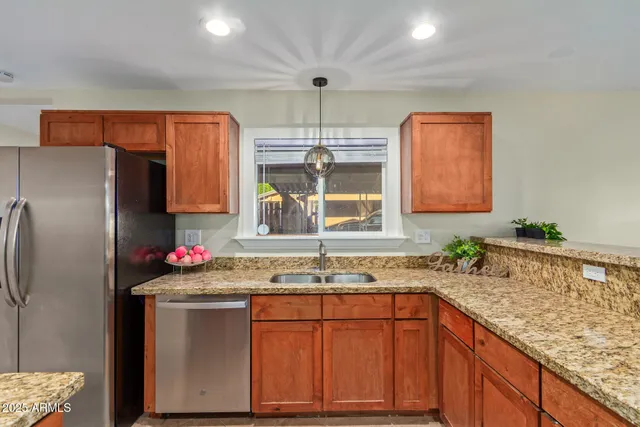 a kitchen with stainless steel appliances granite countertop a sink stove and refrigerator
