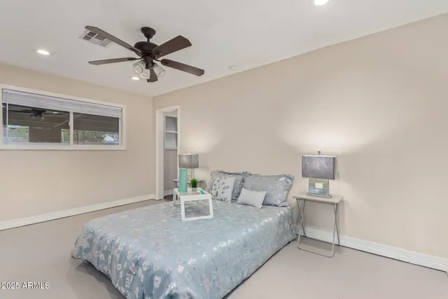 a bed room with a bed a dresser and a chandelier