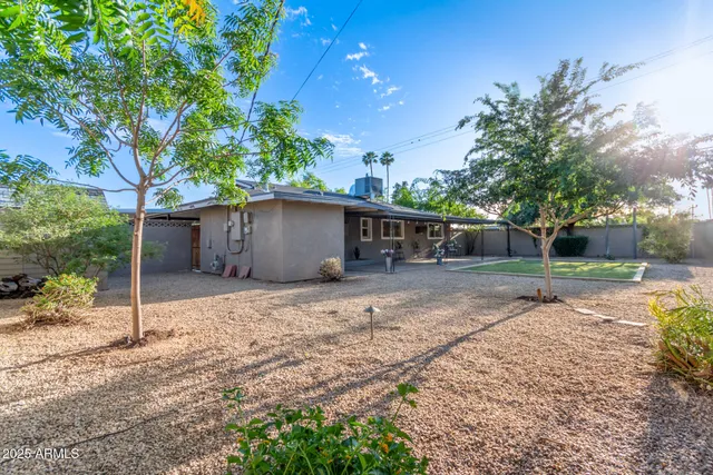 a view of a house with backyard and sitting area