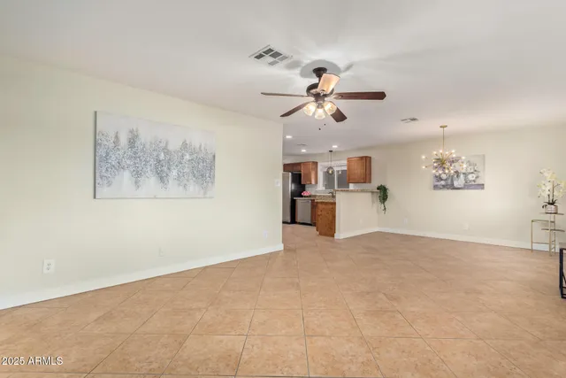 a view of a big room with chandelier fan and windows