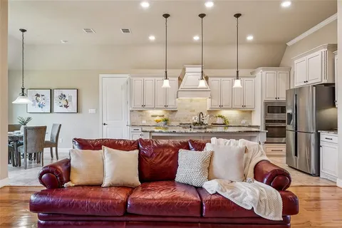 a living room with furniture kitchen and a chandelier