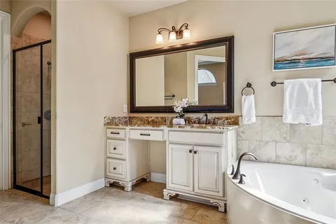 a bathroom with a tub sink and mirror