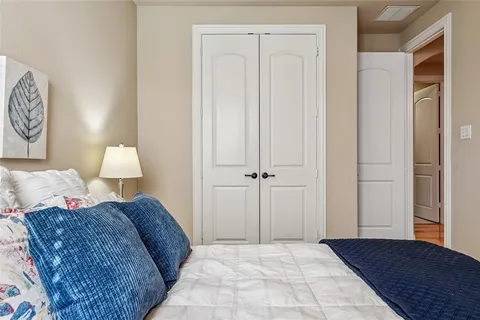 a bedroom with a bed and a lamp on dresser