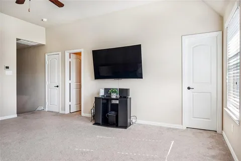a view of an empty room with a flat screen tv and a window