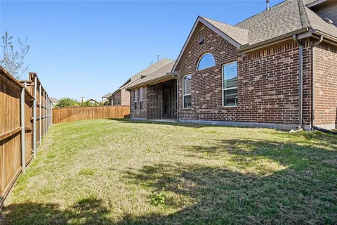 a front view of house with yard and trees in the background