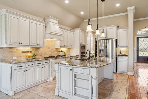 a kitchen with white cabinets and sink