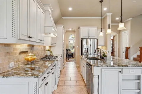 a kitchen with stainless steel appliances granite countertop a sink stove and cabinets