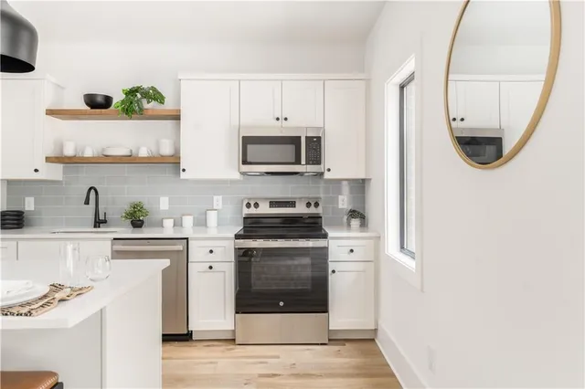 a kitchen with stainless steel appliances granite countertop a stove a microwave and a refrigerator