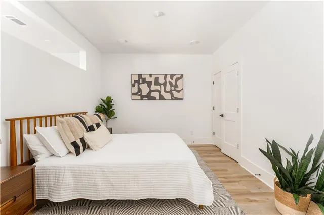 a bedroom with a large bed and a potted plant