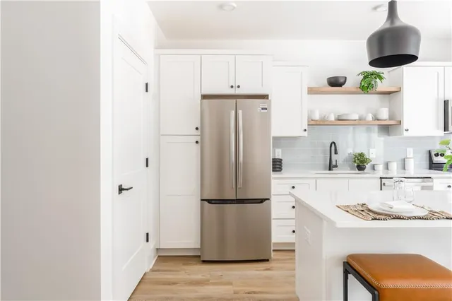 a kitchen with stainless steel appliances granite countertop a refrigerator and a stove