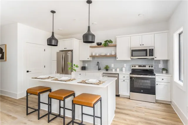 a open kitchen with stainless steel appliances granite countertop a stove a sink and a refrigerator