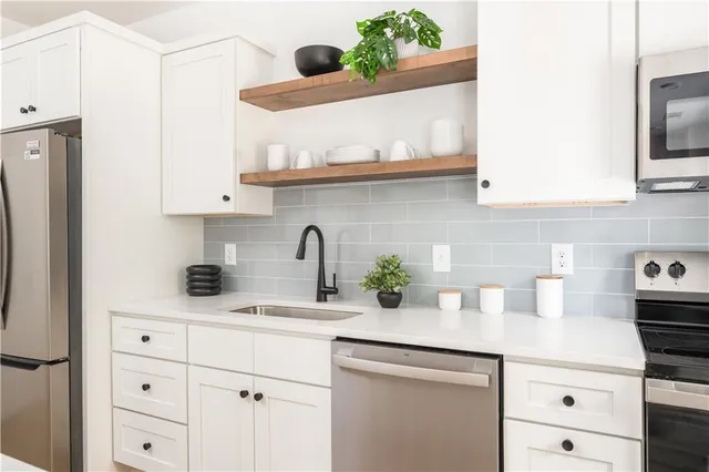 a kitchen with stainless steel appliances a sink stove and cabinets