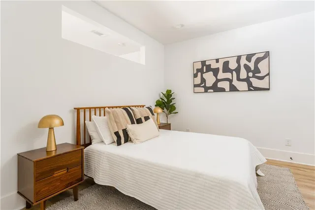 a bedroom with a bed and painting on the wall